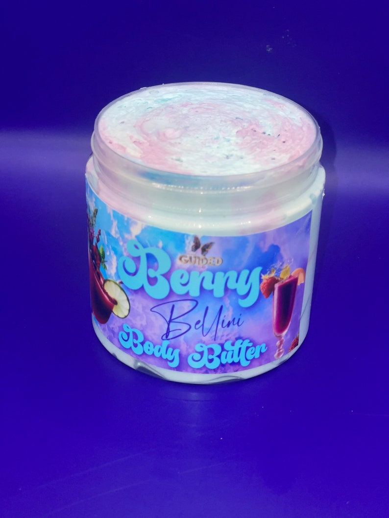 May include: A white jar of whipped body butter with a pink and blue swirl on top. The jar has a label that says "Gourmet Berry Bellini Body Butter".