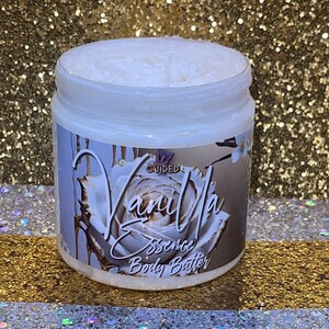 May include: A white jar of vanilla scented body butter with a gold and white label that says "Vanilla Essence Body Butter" and a gold and white rose design.
