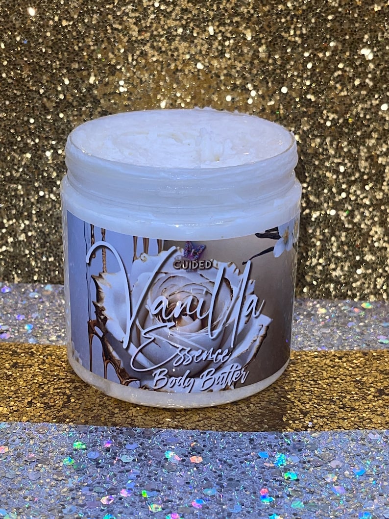 May include: A white jar of vanilla scented body butter with a gold and white label that says "Vanilla Essence Body Butter" and a gold and white rose design.