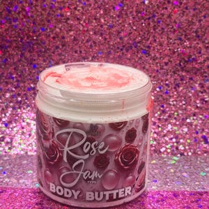 May include: A white jar with a pink lid and a pink and white label. The label says "Guided Rose Jam Type Body Butter".