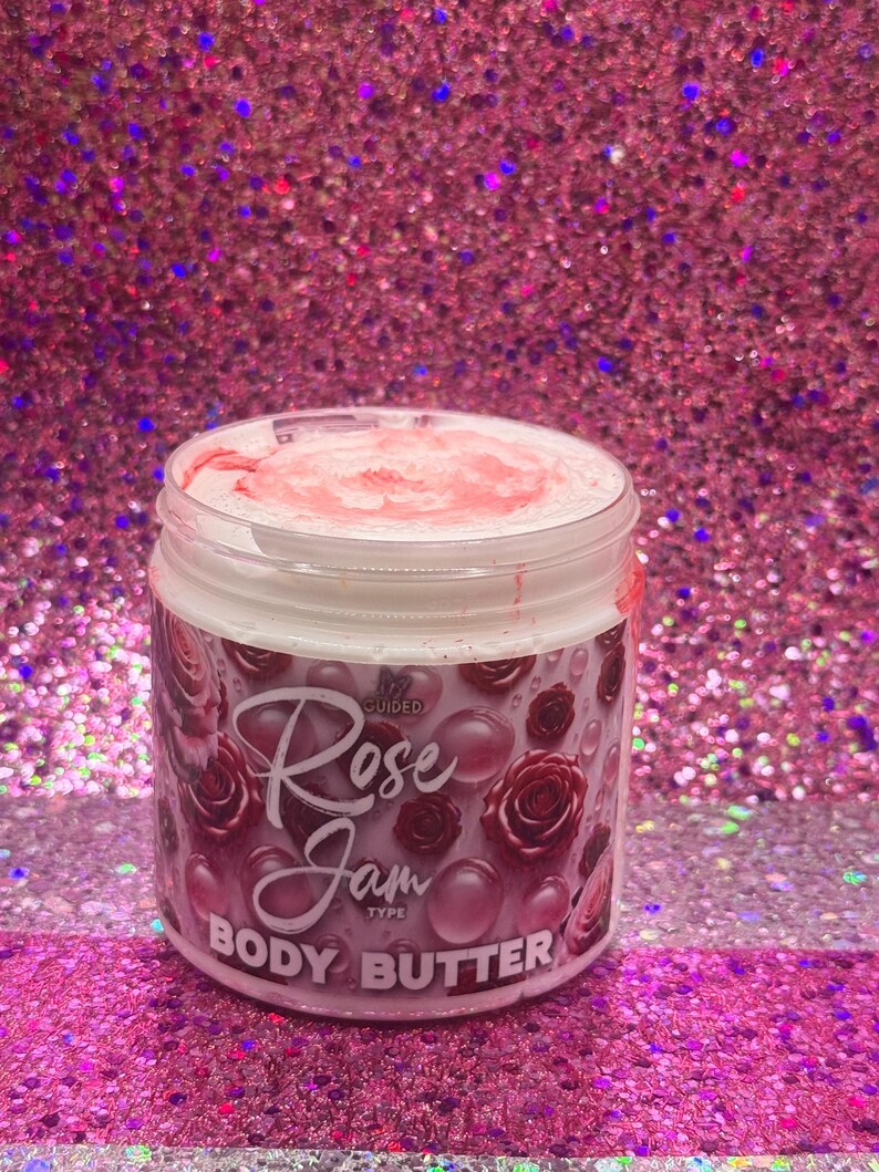 May include: A white jar with a pink lid and a pink and white label. The label says "Guided Rose Jam Type Body Butter".