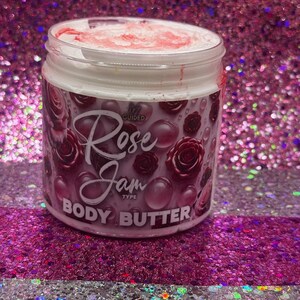 May include: A white jar with a pink lid and a pink and white label. The label says "Guided Rose Jam Type Body Butter".