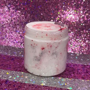 May include: A white jar with a pink and silver glitter swirl inside. The jar is sitting on a pink and silver glitter background.