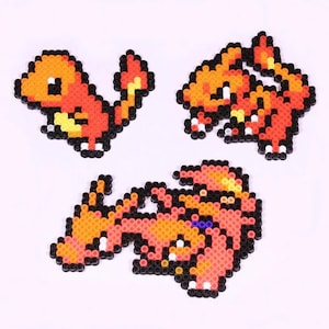 May include: Three pixel art Pokemon figures made of colorful beads. The figures are Charmander, Charmeleon, and Charizard. The figures are all in different poses.