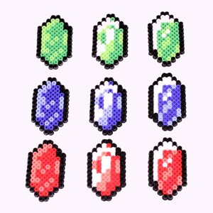 May include: Nine colorful pixelated gems in various shapes and colors, including green, blue, red, and white.