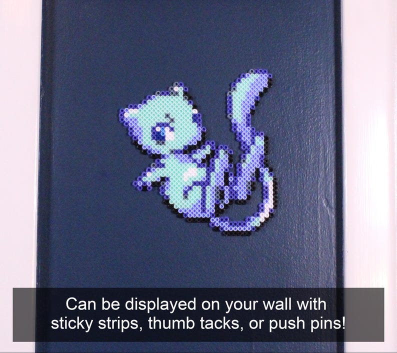 May include: A light blue and purple pixel art cat on a dark blue background. The cat is made of small plastic beads and can be displayed on a wall with sticky strips, thumb tacks, or push pins.