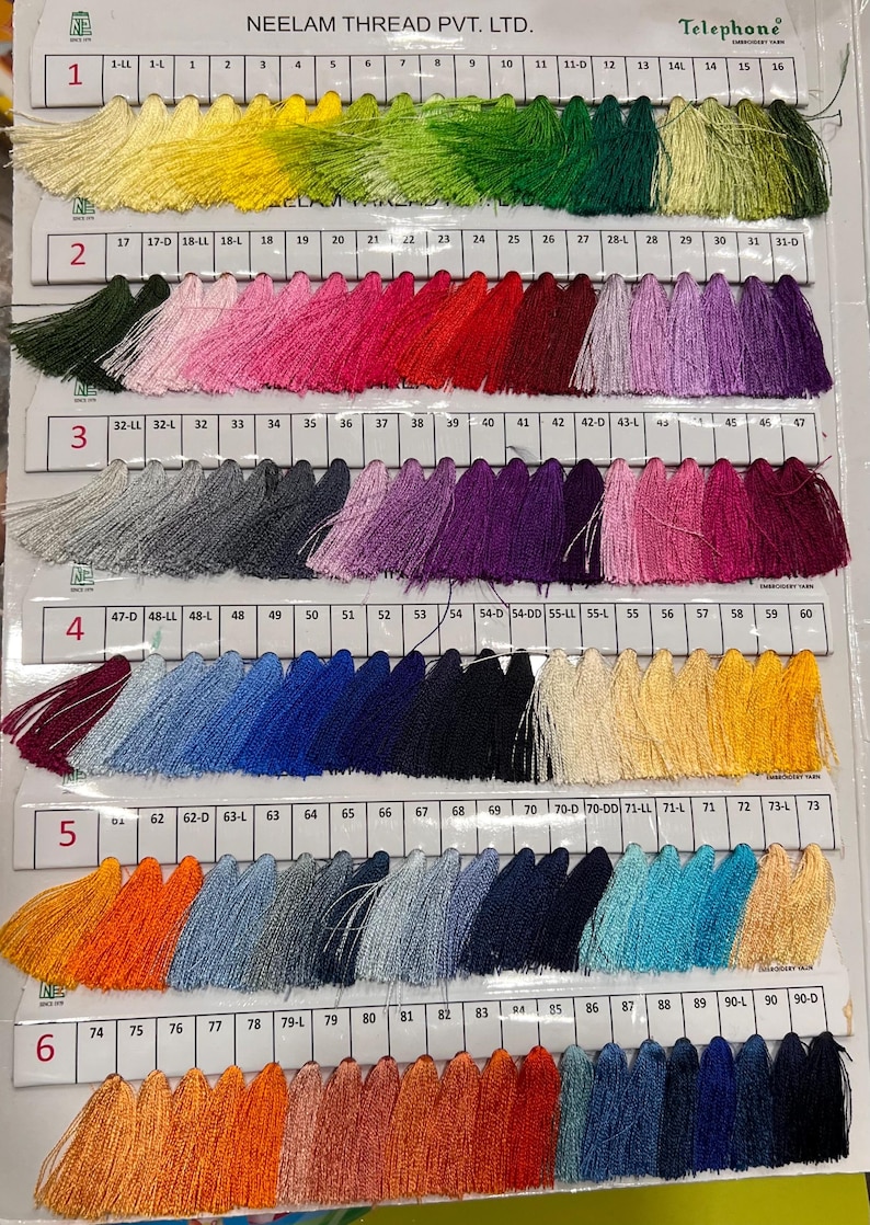 May include: A color chart of embroidery thread tassels in a variety of colors, including yellow, pink, red, purple, blue, and orange. The chart is labeled with numbers and text from Neelam Thread Pvt. Ltd.