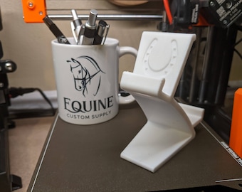 Soporte para teléfono y tableta con forma de herradura: compatible con dispositivos de diversos grosores y con dos ángulos de inclinación.
