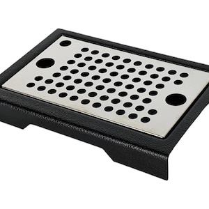 May include: Black rectangular drip tray with a stainless steel perforated insert. The tray has a textured surface and rounded edges.
