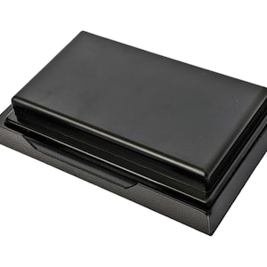 May include: Black plastic storage box with a hinged lid. The lid has a raised edge around the perimeter.