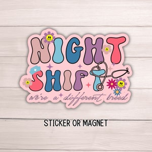 May include: Pink sticker or magnet with the text "NIGHT SHIFT we're a different breed" in colorful, retro-style lettering. The design includes a stethoscope, a nurse's cap, and flowers.