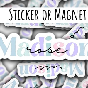Puede incluir: Una pegatina o imán con el nombre "Madison" escrito en una fuente colorida y estilizada. La palabra "rose" está escrita en cursiva debajo del nombre.