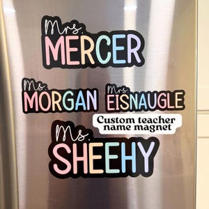 May include: A collection of custom teacher name magnets. Each magnet features a name in a colorful, pastel font with a black outline. The names include "Mercer", "Morgan", "Eisnaugle", and "Sheehy". A smaller magnet reads "Custom teacher name magnet".