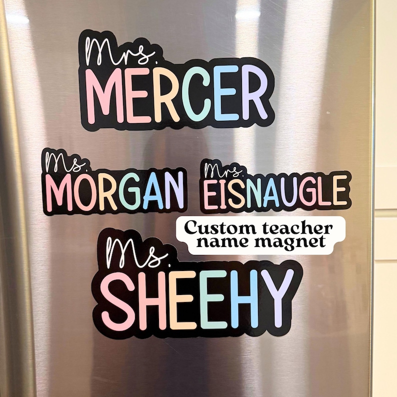 May include: A collection of custom teacher name magnets. Each magnet features a name in a colorful, pastel font with a black outline. The names include "Mercer", "Morgan", "Eisnaugle", and "Sheehy". A smaller magnet reads "Custom teacher name magnet".