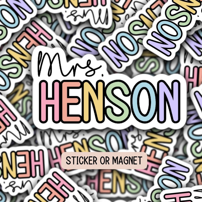 May include: A colorful sticker or magnet with the text "Mrs. Henson" in rainbow colors. The sticker is surrounded by other stickers with the same text in different colors.