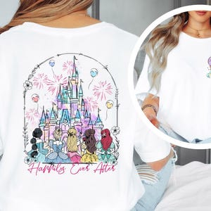 May include: White t-shirt featuring a colorful illustration of a castle with fireworks and the text "Happily Ever After." The back of the shirt showcases a detailed design of a castle and several figures. A smaller design is on the front.