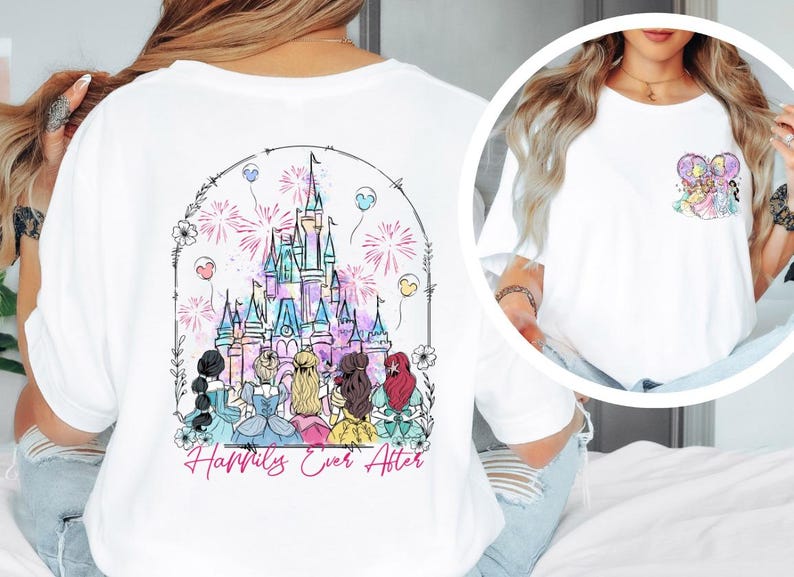 May include: White t-shirt featuring a colorful illustration of a castle with fireworks and the text "Happily Ever After." The back of the shirt showcases a detailed design of a castle and several figures. A smaller design is on the front.