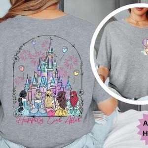 May include: Athletic heather gray t-shirt featuring a colorful illustration of a castle with fireworks and the text "Happily Ever After." The shirt also has a smaller graphic on the chest. The shirt is made of a soft material.