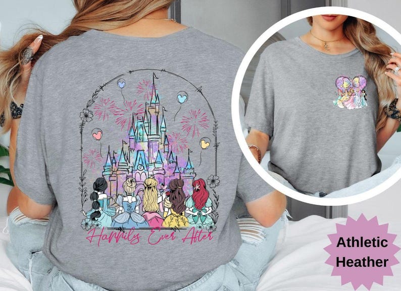 May include: Athletic heather gray t-shirt featuring a colorful illustration of a castle with fireworks and the text "Happily Ever After." The shirt also has a smaller graphic on the chest. The shirt is made of a soft material.