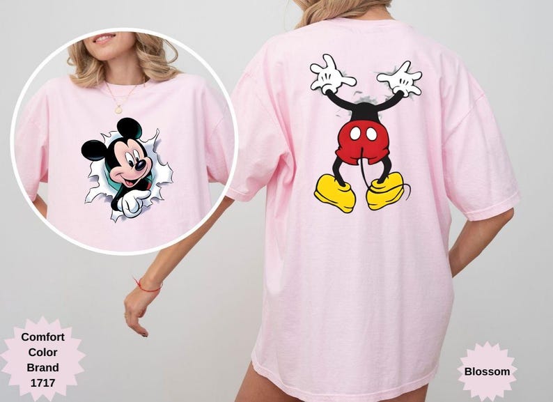 Peut inclure: T-shirt rose clair avec un motif de Mickey Mouse. L'avant du t-shirt montre Mickey per&ccedil;ant un trou d&eacute;chir&eacute;, tandis que le dos affiche le dos de Mickey. Le t-shirt est de la marque Comfort Color.