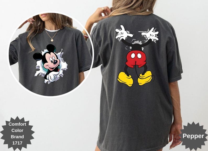 Peut inclure: T-shirt gris fonc&eacute; avec Mickey Mouse. L'avant du t-shirt montre Mickey per&ccedil;ant un trou d&eacute;chir&eacute;, tandis que le dos affiche la pose embl&eacute;matique de Mickey, les bras lev&eacute;s. Le t-shirt a un aspect vintage et d&eacute;lav&eacute;.