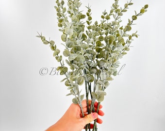 May include: A bunch of artificial eucalyptus stems with green and white leaves.