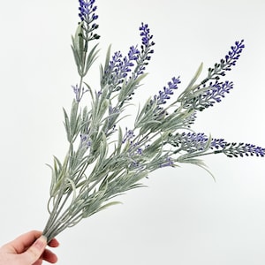 Op de afbeelding: Een bos kunstmatige lavendelstengels met paarse bloemen en groene bladeren.
