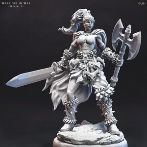 May include: A white 3D printed miniature of a female warrior with a sword and axe. She is wearing a horned helmet, a leather skirt, and fur bracers. The miniature is standing on a rocky base.