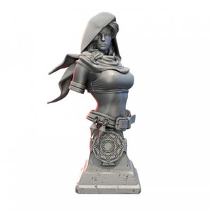 Puede incluir: Busto gris de una mujer con una capa con capucha y un cinturón con un emblema circular. La escultura tiene rasgos faciales detallados y está montada sobre una base rectangular. El busto es una obra de arte de temática fantástica.