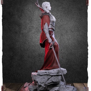May include: A white female figurine with long white hair and a red robe, holding a sword. The figurine is standing on a rocky base.