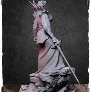 May include: A white painted figurine of a person wearing a flowing robe and holding a sword. The figurine is standing on a rocky base.