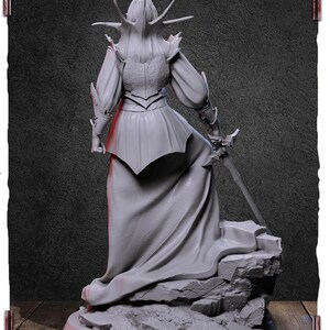 May include: A gray, detailed, 3D printed figurine of a female figure wearing a flowing gown and armor, holding a sword. The figure is standing on a rocky base.