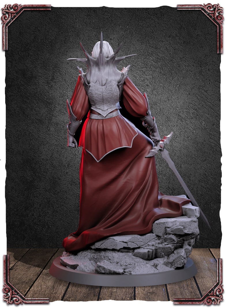 May include: A detailed figurine of a female figure in a red gown and armor, standing on a rocky base. The figure has a spiky crown and holds a sword.