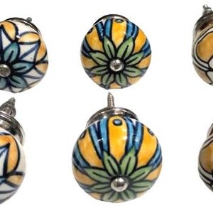 May include: Six ceramic cabinet knobs with floral designs in shades of yellow, blue and green. The knobs have a silver finish and are perfect for adding a touch of farmhouse style to your home.