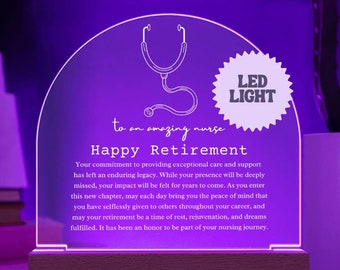 May include: A purple LED light with a white outline of a stethoscope and the text "to an amazing nurse Happy Retirement". The light has a white wooden base and a white starburst with the text "LED LIGHT" in the top right corner.