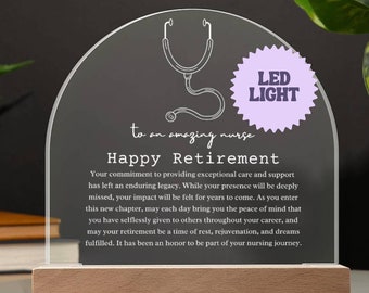 May include: A clear acrylic plaque with a stethoscope design and the text "to an amazing nurse Happy Retirement". The plaque is illuminated by a purple LED light and sits on a wooden base.