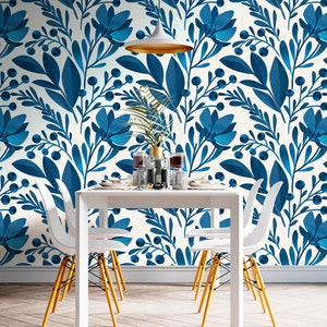 May include: A white dining table with four white chairs and yellow legs. The table is set with white plates, glasses, and silverware. The wall behind the table is covered in a blue and white floral wallpaper.