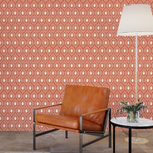 May include: A mid-century modern living room scene featuring a rust-colored patterned wallpaper, a brown leather armchair, a white lamp, and a small round table with a marble top. The room has a minimalist design.