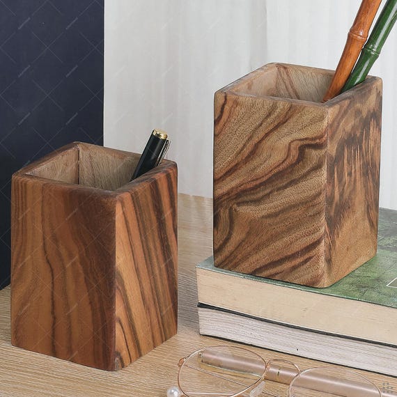 Solid camphor wood with its wild natural grain and aromatic scent makes this pen holder a desk sculpture, not just storage.