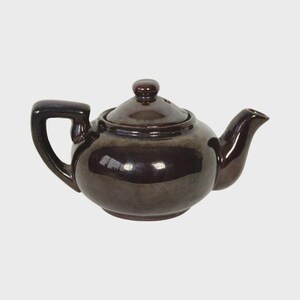 May include: A brown ceramic teapot with a lid and a curved spout. The teapot has a handle and a small knob on the lid. The teapot is a dark brown color with a glossy finish. The teapot is designed for brewing tea.