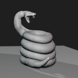 Könnte beinhalten: Eine graue, gewickelte Schlangenskulptur mit erhobenem Kopf und offenem Maul, als würde sie zuschlagen. Die Schlange ist aus einem glatten, strukturierten Material gefertigt und ist eine realistische Darstellung einer Schlange.