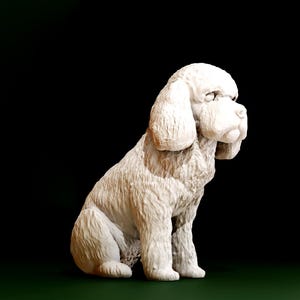 May include: A white dog sculpture in a seated position, featuring a fluffy coat and drooping ears. The dog is facing left, with a textured surface. The background is a dark green to black gradient.