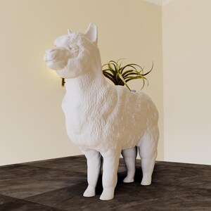 May include: White ceramic alpaca planter with a small green plant growing inside. The planter is shaped like an alpaca standing on all four legs.