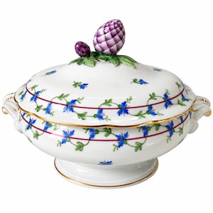 Può includere: Una zuppiera in porcellana bianca con coperchio caratterizzato da un pomello a forma di carciofo viola scolpito e foglie verdi. Il corpo e il coperchio presentano un motivo di fiori blu, viticci verdi e sottili linee rosse, con bordo oro.