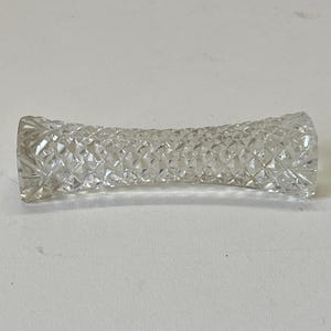 May include: A clear glass paperweight with a diamond pattern.