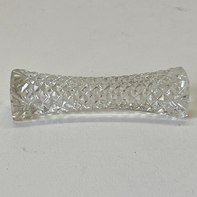 May include: A clear glass paperweight with a diamond pattern.