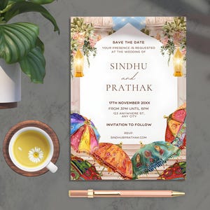 May include: Save the date wedding invitation card featuring a watercolour illustration of a colourful archway adorned with flowers and lanterns. The text reads "Save the Date, Your presence is requested at the wedding of Sindhu and Prathak, 17th November 20XX, From 3PM until 6PM, 123 Anywhere St., Any City, Invitation to Follow, RSVP, Sindhubpratha.com".