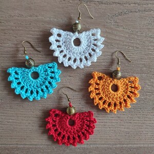 Peut inclure: Quatre paires de boucles d'oreilles en crochet avec un accent de perle en laiton. Les boucles d'oreilles sont en blanc, bleu, orange et rouge.