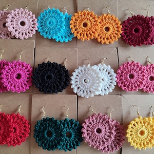 May include: Assortment of crocheted earrings in various colors, including pink, blue, black, white, red, green, and yellow. The earrings are all circular and have a delicate, lacy design.