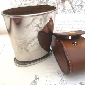 Étrier pliant vintage en métal blanc dans un étui en cuir de forme ovale inhabituelle